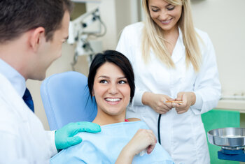 girl in dentist chair greeted by dentist and assistant before procedure. Cedar City, UT tooth colored fillings