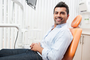 man smiling sitting in dentist chair, Cedar City, UT dental implants